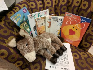 Storytime books on chair, with donkey puppet and coloring sheets