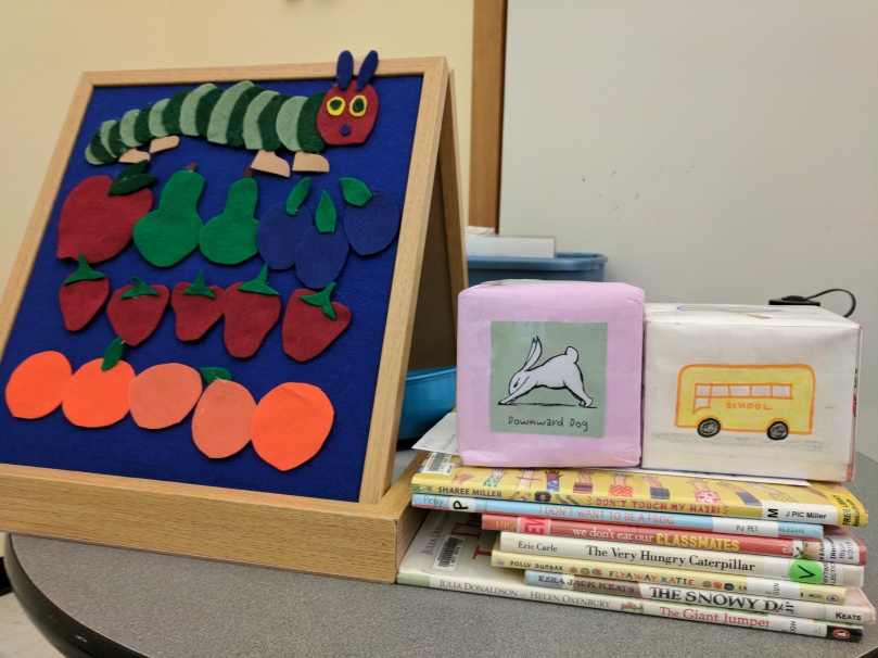 Flannel board with caterpillar and fruit, yoga cube, song cube, picture books